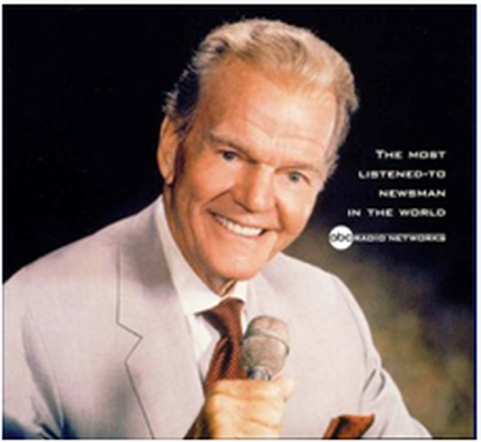 A photograph of a man holding a microphone and smiling. He is wearing a light grey suit and a red tie. The background is black and the man is in the center of the image. The text on the image reads "The Most Listened-to-Newman in the World" and "Radio Network". The man appears to be in his late 60s or early 70s with short white hair and a slight smile on his face. He looks confident and happy.