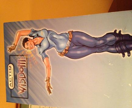 A digital illustration of a woman in a superhero costume. She is in mid-air with her arms stretched out to the sides and her legs bent at the knees. She has a determined expression on her face and her eyes are focused on something in the distance. The background is a light blue color with rays of light shining down on her. The word "Wisdom" is written in bold white letters at the bottom of the image. The illustration is done in a cartoon-like style with bright colors and exaggerated features.