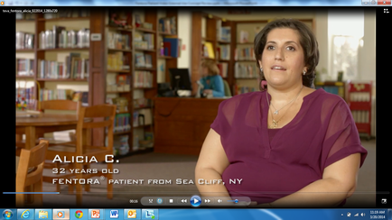 A screenshot of a video interview with Alicia C. mentor a 32-year-old patient from Sea Cliff NY. She is sitting in a library with bookshelves in the background. Alicia is wearing a purple blouse and has shoulder-length dark hair. She appears to be in her late 30s or early 40s and is looking off to the side with a serious expression on her face. The text on the image reads "32 years old mentor PATIENT FROM SEA CLIFF NY".