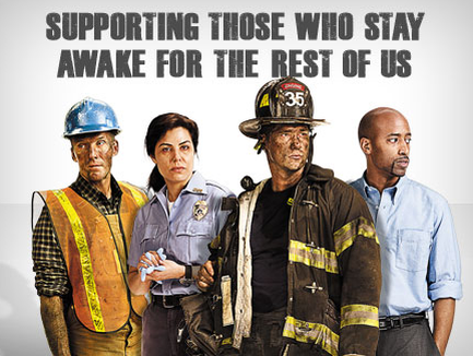 A group of four people two men and two women standing together and posing for a photo. The man on the left is wearing a blue hard hat and a yellow safety vest the man in the middle is holding a clipboard and the woman on the right is holding an object. All four people are wearing firefighter uniforms and helmets. The background is white and there is text above them that reads "Supporting those who stay awake for the rest of us."