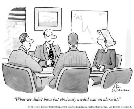 A black and white cartoon illustration of a group of four people sitting around a conference table in a meeting room. There are three people in the image two men and two women all dressed in formal business attire. The man on the left is holding a piece of paper and appears to be explaining something to the two men on the right. The woman on the far right is looking at the man in the center with a concerned expression on her face. In the background there is a whiteboard with a graph on it and a framed picture hanging on the wall. The text on the image reads "What we didn't have but obviously needed was an alarmist."