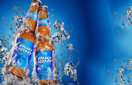 Two Bud Light beer bottles splashing in the air. The bottles are orange in color and have the Bud Light logo on them. The background is a deep blue color and there are several ice cubes scattered around the bottles. The ice cubes are white and appear to be floating in mid-air. The image has a dynamic and energetic feel to it.