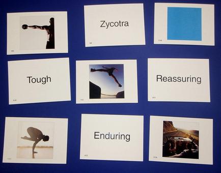 A collection of nine square cards arranged in a grid-like pattern on a blue background. Each card has a different word written on it in black text. The word "socotra" is written in bold letters at the top of each card. The first card on the top left has a black and white photograph of a person holding a dumbbell in their hand. The second card has the word "Tough" written in a cursive font. The third card has an image of a woman in mid-air with her arms stretched out to the sides. The fourth card has text that reads "Reassuring" and the fifth card has two images of a man in a suit and tie. The sixth card has three images of the same person one in a black suit and the other in a white suit. The seventh card has four images of two people in a car one with a blue square in the top right corner. The eighth card has five images of another person in the bottom left corner the ninth card has six images in the middle and the tenth card has seven images in front of it. Overall the image appears to be a visual representation of the concept of "enduring" or "reassuring".