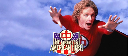 A promotional poster for the TV show "The Greatest American Hero". It features a man with curly blonde hair wearing a red superhero costume with a black cape. He is flying through the air with his arms stretched out wide and his mouth open as if he is shouting or shouting. The background is a blue sky with white clouds. In the center of the image there is a logo with the show's title and logo.
