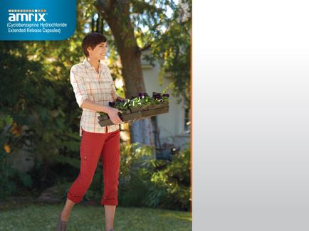 A young woman walking in a garden. She is wearing a white shirt with a red plaid pattern and red pants. She has short dark hair and is carrying a wooden tray filled with purple and green plants. The tray appears to be made of wood and has a handle on one side. The woman is smiling and seems to be enjoying her walk. In the background there are trees and bushes and a house can be seen in the distance. The image is accompanied by the logo of Amrix a company that provides hydroponic gardening products.
