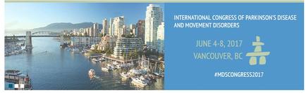A photograph of the city of Vancouver British Columbia Canada. The photograph is taken from a high vantage point looking down on the city. The city is filled with tall buildings and skyscrapers and there is a bridge crossing over the water. The sky is blue and there are mountains in the background. On the right side of the image there is text that reads "International Congress of Parkinson's Disease and Movement Disorders" and "June 4-8 2017 Vancouver BC #MDSCONGRESS2017".