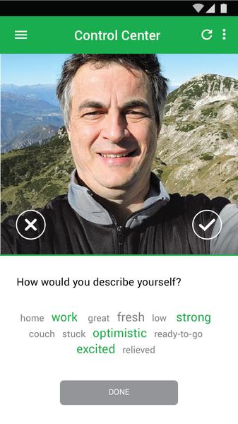 A screenshot of a mobile phone screen with a photo of a man on the top right corner. The man is smiling and looking directly at the camera. He is wearing a black jacket and has short grey hair. The background of the photo is a beautiful landscape of mountains and a clear blue sky. Below the photo there is a text message that reads "How would you describe yourself? home work great fresh low strong couch stuck optimistic ready-to-go excited relieved." There is also a checkmate next to the text message. At the bottom of the screen there are two buttons - "Done" and "Cancel".