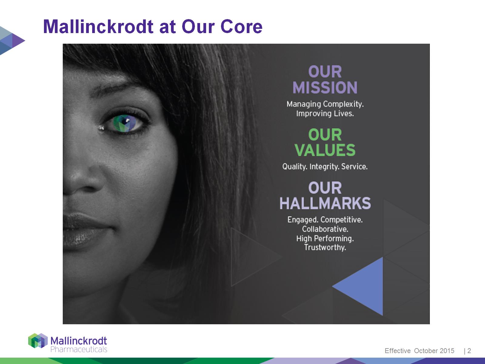 A slide from a presentation titled "Mallinckrodt at Our Core". The slide features a photograph with a dark background with a purple and blue geometric pattern. On the left side there is a close-up black-and-white photograph of a woman's face with short dark hair. Her eyes are the blue and green colors of the Mallinckrodt logo. She is looking directly at the camera with a serious expression. The text on the page reads "Our mission: Managing complexity improving lives. Our values. Quality integrity service. Our Hallmarks. Engaged competitive collaborative high performing trustworthy." At the bottom of the page there is the Mallinckrodt logo and text that reads "Effective October 2015." 