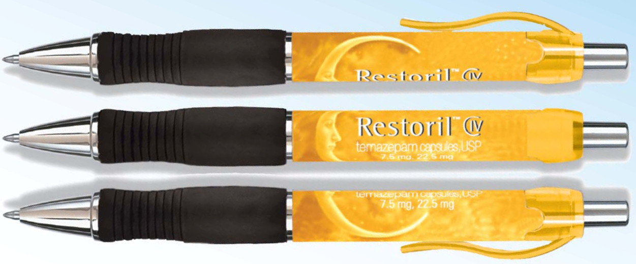 Three ink pens intended as promotional items to advertise Restoril CIV (temazepam capsules USP 7.5 mg 22.5 mg). The pens are all identical but are rotated slightly differently to show how the Restoril advertisement would appear from various angles. The pens are silver with a black pad on the barrel with orange labels and clips. The label includes a drawing of a crescent moon with text in white including the Restoril logo (which is outlined in black).