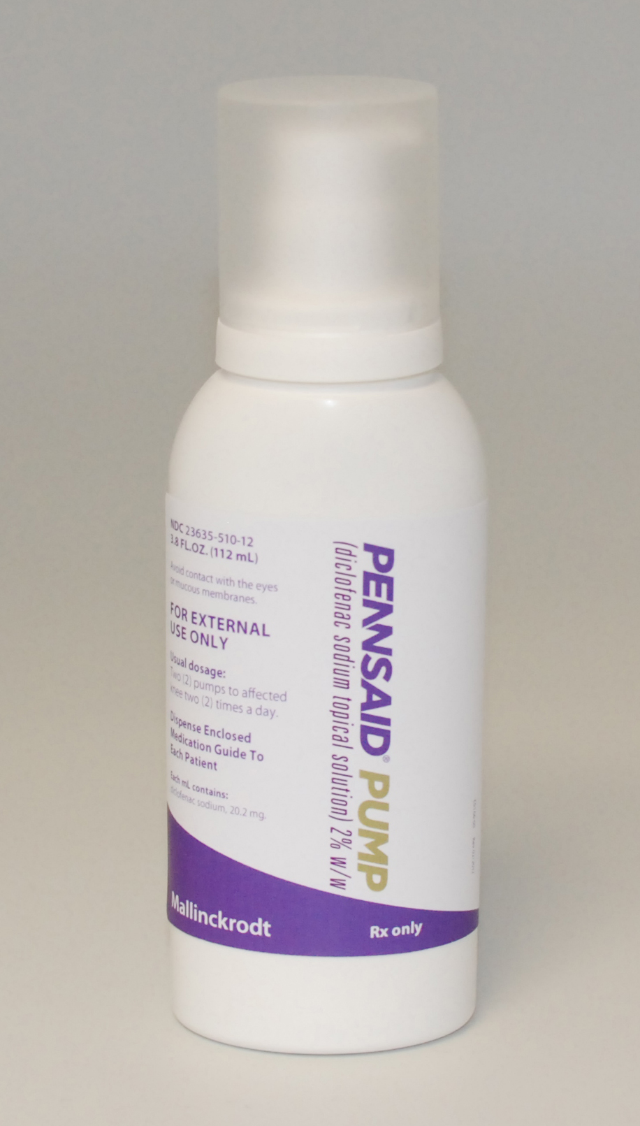 Of a white plastic bottle with a purple and white label. The label reads "Pennsaid Pump" written in bold letters at the top. It also includes the text "For External Use Only" in smaller purple letters. Below that there is a description of how to use the product. The bottle has a white cap and is standing upright on a plain white background.