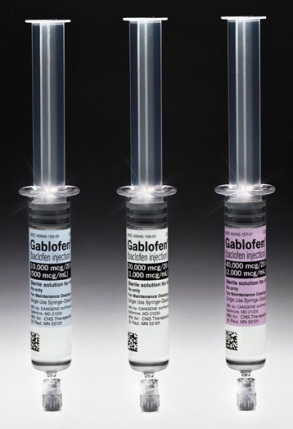 Three prefilled syringes of Gablofen (baclofen injection) of various dosages (40000 mcg/20 ml - 20000 mcg/20 ml - 10000 mcg/20 ml). The syringes are made of clear plastic and have a cylindrical shape with labels of various colors (blue yellow and purple respectively) with text in black with a QR code at the bottom. The background is a gradient fading from black (at the top) to white (at the bottom) with the syringes appearing to be floating in space.