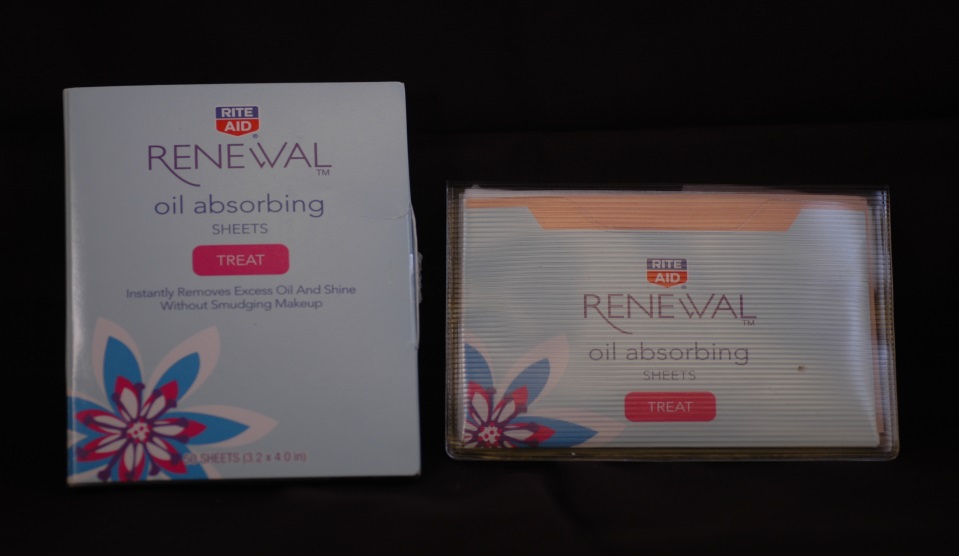 A box of Renewal Oil Absorbing Sheets. The box is rectangular in shape and has a white background with a blue and pink floral design on the front. The front of the box has the brand name "Renewal" written in bold black letters. Below that there is a description of the product which states that it instantly removes excess oil and shine without smudging makeup. <br /><br />Next to the box there are two smaller boxes of the same product. The first box is white with a pink and blue floral design while the second box is orange with the same design. Both boxes have a label that reads "Treat" in red letters. The boxes appear to be new and unused.