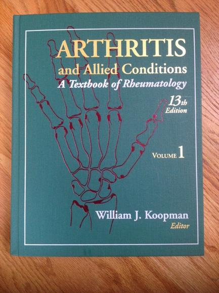 The cover of a book titled "Arthritis and Allied Conditions: A Textbook of hematology Volume 1". The cover is predominantly green with a red illustration of a hand in the center. The hand is drawn in a sketch-like style with thin lines and curves. The title of the book is written in white text at the top of the cover with the author's name William J. doorman written in smaller text below. The subtitle "13th Edition" is written at the bottom. The book appears to be a hardcover with a glossy finish.