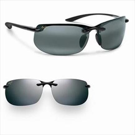 Two pairs of sunglasses. The first pair is a pair of rectangular sunglasses with a black frame and dark grey lenses. The frame is made of a shiny black material and has a curved shape. The temples of the sunglasses are also black and have a small gold-colored logo on the temples. The lenses are polarized and appear to be a dark grey color. The sunglasses are resting on a white background.