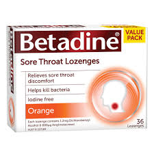 Of a Value Pack box of Betadine Sore Throat Lozenges. The box is white with graphic elements in red orange and yellow with text in red and white. The box lists product benefits : "Relieves sore throat discomfort" "Helps kill bacteria" "Iodine free". The flavor is orange and there are 36 tablets. There is also a silhouette of a human head in profile with a red dot in the throat area surrounded by orange and silver circles.