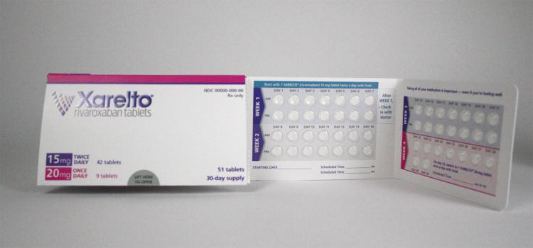 A pack of Xarelto (rivaroxaban) tablets. The box is white with graphic elements in purple and hot pink with text in black and purple. It contains a 30-day supply consisting of 51 tablets : 42 tablets in the 15mg dosage (intended to be used twice per day for the first 3 weeks) and 9 tablets in the 20mg dosage (intended to be used once per day for week 4 through the rest of the month). The blister packs containing those pills are also shown. They have a white background with graphic elements in gray red teal purple and hot pink with text in black and purple.