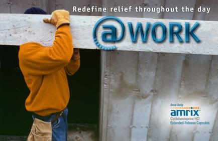 A construction worker wearing a yellow goodie and gloves working on a concrete wall. He is holding a large piece of concrete with both hands and appears to be in the process of removing it from the wall. The background is blurred but it seems like the worker is standing in front of a building under construction. The text on the image reads "Redefine relief throughout the day @work" and there is a logo for Amrix a company that provides extended-release capsules.