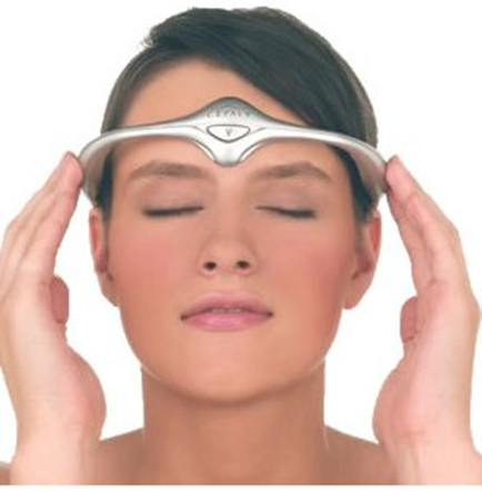 A young woman with her eyes closed holding a silver headband over her head. The headband has a triangular design on it and appears to be made of metal. The woman has short dark hair and is wearing minimal makeup. She is looking directly at the camera with a peaceful expression on her face. The background is plain white.