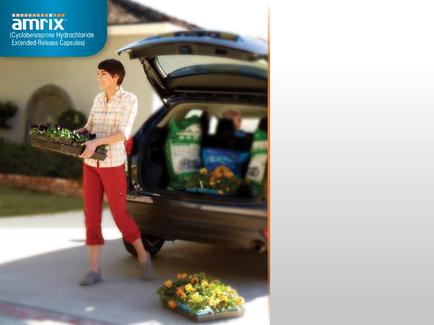 A young woman standing next to a car with the trunk open. She is holding a tray of plants in her hands and appears to be loading them into the trunk. The car is parked on a driveway with a house in the background. There are several bags of food items in the trunk including a bag of chips and a container of vegetables. The woman is wearing a white shirt and red pants and is smiling as she walks towards the car. There is a flower bed in front of the car with orange and yellow flowers. The image also has a blue banner on the top left corner that reads "amrix" and a logo for Amrix.
