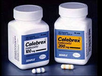 Two white plastic bottles with blue labels. The bottles are labeled "celebes 100mg" and "200mg". The labels also mention that the bottles contain 100mg of the medication. There are a few small white pills scattered around the bottles. The background is black making the bottles and pills stand out.