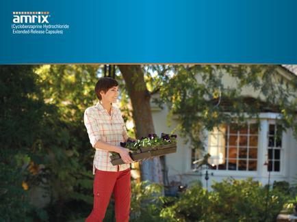 A young woman standing in a garden holding a wooden tray with a variety of plants in it. She is wearing a white shirt and red pants and has short dark hair. The tray is filled with purple and green plants and she is smiling as she walks through the garden. In the background there is a white house with a large window and a tree with green leaves. The sky is blue and the sun is shining through the trees creating a warm and inviting atmosphere. The image appears to be a promotional advertisement for Amrix a company that offers extended-release capsules.