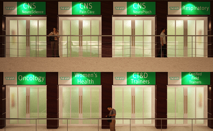 The entrance of a building with multiple elevators. The elevators are arranged in a row and each elevator has a green sign that reads "CNS NeuroScience" "Pain Care" "NeuroPsych" "Respiratory" "Oncology" "woman's Health" "CT&D Trainers" and "Certified Field Trainers". There are two people standing in front of the elevators one of them is holding a clipboard and the other is looking at the sign. The building appears to be a hospital or clinic as there are medical equipment visible in the background.